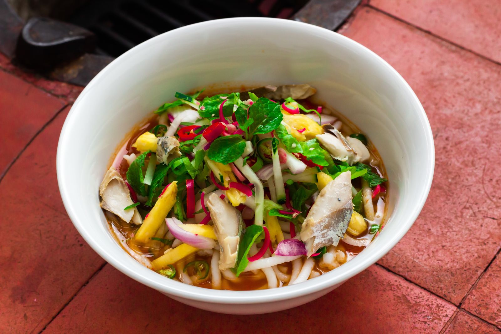 Penang assam laksa with fresh herbs and pineapple